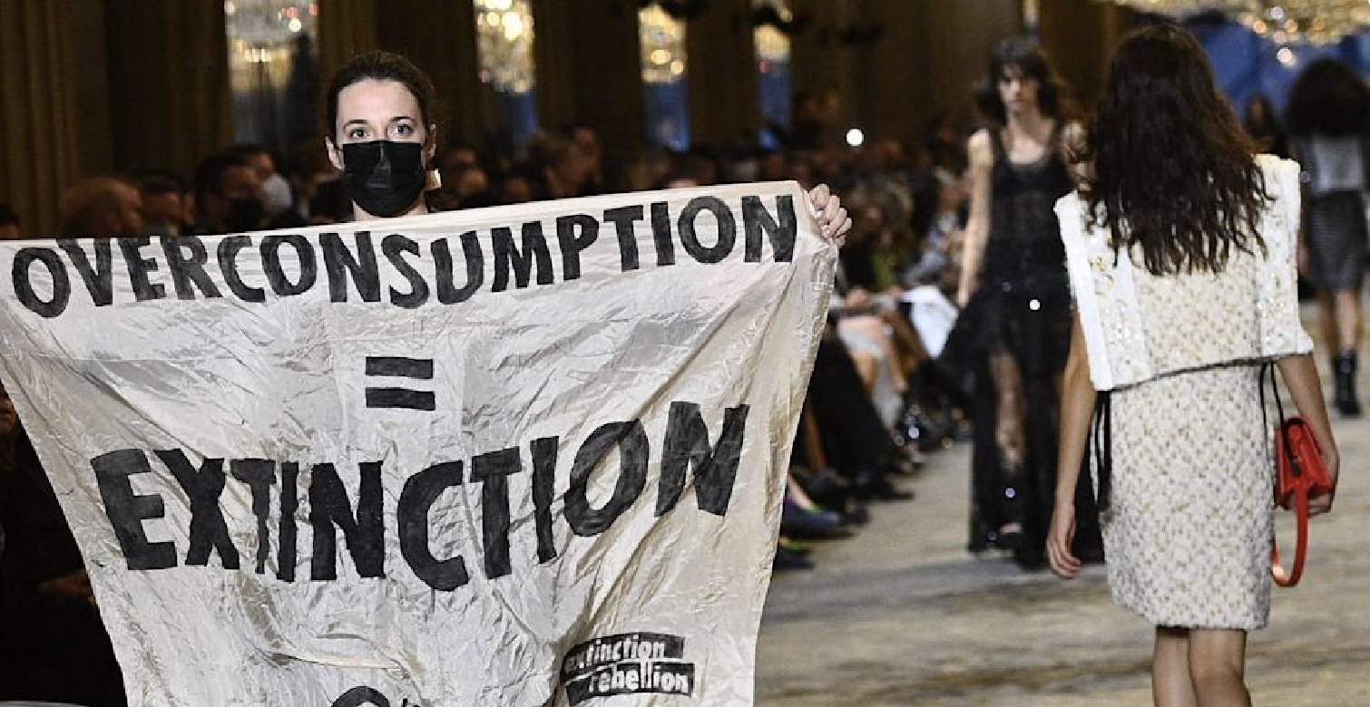 Protester with climate change banner crashes Louis Vuitton show, tackled by  security